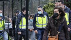 El �nico acusado, en el medio, con ropa gris y esposado, saliendo de la vivienda del crimen