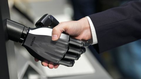 Una persona estrecha una mano rob�tica en el Mobile de Barcelona