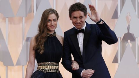 Eddie Redmayne con un traje azul de Alexander McQueen, acompaado de su mujer