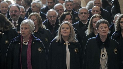 Tres mujeres durante la ceremonia de ayer en la iglesia de los Escolapios, con las capas que las identifica como cofrades de la Cofrada Europea de la Vela