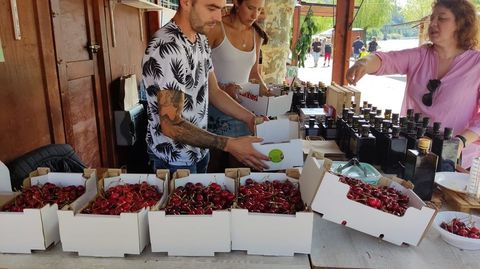 Aceite local y cerezas en uno de los puestos de la fiesta, este domingo en la playa fluvial del Sil, en San Clodio