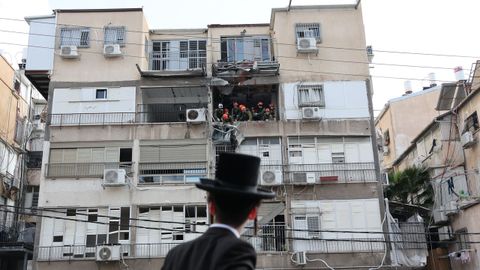 Un ultraortodoxo observa trabajos en un edificio con destrozos en Teher�n.