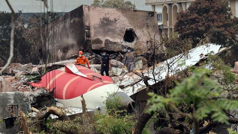 Funcionarios del Goberno indio inspeccionan los restos del avión siniestrado cerca del aeropuerto de Ahmedabad