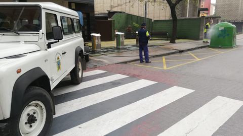 Dos operarios de los Servicios Operativos de Langreo desinfectan un punto con contenedores en una calle de La Felguera.
