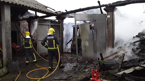 Bomberos del parque de Chantada en las tareas del extinci�n del incendio, que provoc� el derrumbe de la cubierta del alpendre