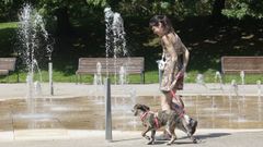 Una chica pasea a su perro en el parque de Vio�o