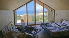 Dormitorio de una de las caba�as del complejo, con impresionantes vistas de la playa de Doni�os