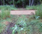 En la imagen superior, los escombros que aparecieron ayer en la ribera del Cabe. A la derecha, marcas del veh�culo que accedi� al paseo fluvial para depositarlos. 