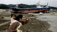 Una mujer camina con su hija por las ruinas de Fukushima