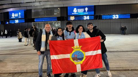 La familia Vidal Roca, con la bandera de A Guarda, en el exterior del Santiago Bernabu.
