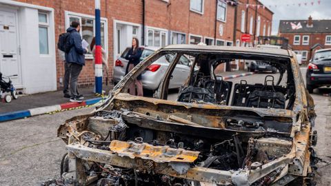 Coches calcinados tras los disturbios en Belfast.