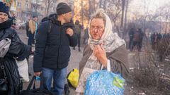 Una mujer herida camina por la calle tras ser evacuada de un edificio bombardeado en Kiev