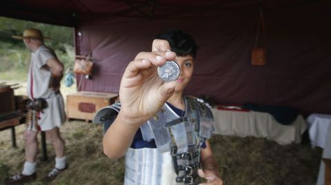 Un integrante de Caetra Lucensium muestra una reproducci�n acu�ada all� mismo del denominado sextercio de la caetra, una moneda del siglo I que probablemente tiene su origen en el Lugo romano