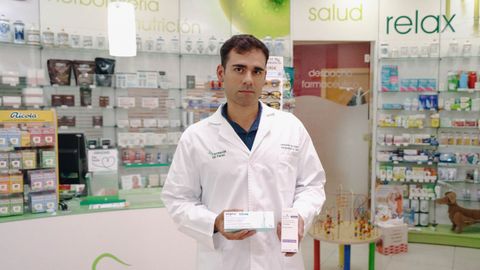 El farmac�utico Fernando Gil posa en su farmacia de Ourense�sosteniendo dos medicamentos an�logos.