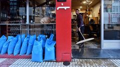 Imagen de un hostelero limpiando su negocio en una de las inundaciones que ha sufrido la zona de As Bra�as