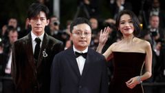 El realizador Bi Gan, entre los actores Jackson Yee y Shu Qi, en la alfombra roja para la presentacin de su ltimo filme, Resurrection.