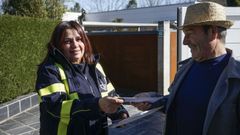 Lourdes Portabales entrega la correspondencia a un vecino de O Penedo (Pereiro de Aguiar)