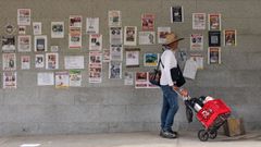 Un hombre camina ante carteles de personas desaparecidas por los se�smos, en La Guaira