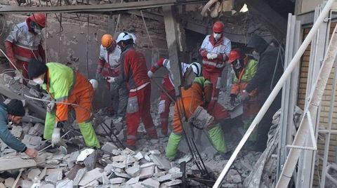 Miembros de la Media Luna Roja trabajan en un edificio bombardeado en Teher�n.