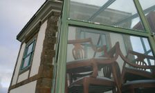 Sillas apiladas en la entrada del Sem�foro que da a la terraza, en frente del Faro Fisterra. 