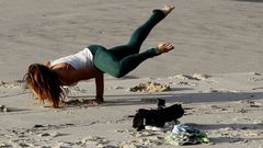 Una joven practicando yoga en una playa de Vigo.