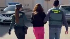 Una de las detenidas, escoltada por dos guardias