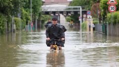 Un hombre montado en una bicicleta en una calle anegada de la ciudad de Lugo, en la regi�n de Emilia-Roma�a