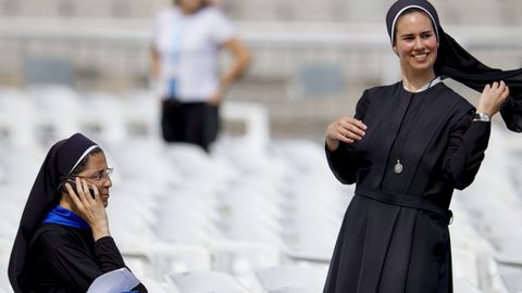 Dos monjas esperan a que empiece la vigilia de 40.000 personas del papa Le�n XIV en el Estadio Ol�mpico de Barcelona.