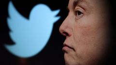 Elon Musk delante del logo de la antigua Twitter