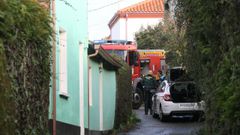 Polic�as y bomberos en la entrada de la vivienda donde aparecieron los dos hombres fallecidos