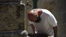 Un hombre se refresca en una fuente, en Combarro. 