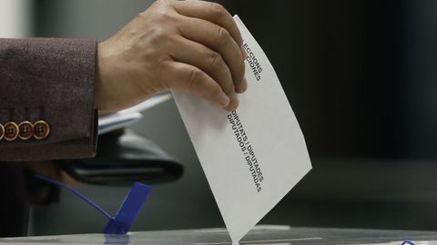 Una ciudadana deposita su voto en una urna electoral con motivo de los comicios catalanes