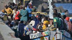 Decenas de inmigrantes, a su llegada en cayuco al puerto de La Restinga, en El Hierro.