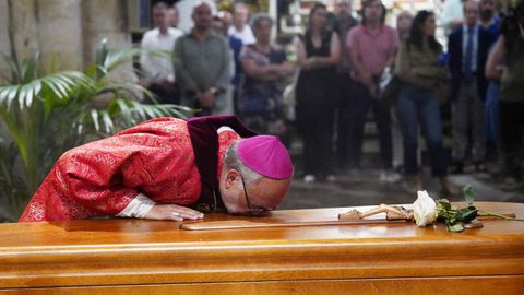 El arzobispo de Oviedo,Jesús Sanz Montes besa el féretro de Antonio Trevín durante su responso