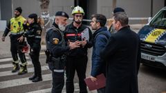 Agentes de la Polic�a Local de Valencia atienden a los vecinos del edificio incendiado el pasado jueves que se sald� con diez v�ctimas mortales