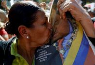 Una mujer besa el retrato de Hugo Ch�vez durante el acto en su homenaje ayer en Caracas.