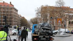 Una gra municipal traslada un coche daado por los cascotes de la explosin de ayer en la calle Toledo, en Madrid