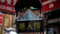 Un manifestante, cubierto por una mascarilla y utilizando su mvil a modo de pancarta, en las protestas contra la ley de seguridad nacional en Hong Kong