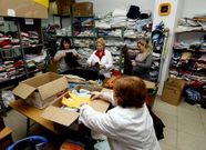 Voluntarios de la entidad vinculada a la Iglesia clasificando ropa en el almac�n.