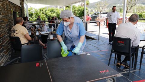 Limpiando la mesa de la terraza de un establecimiento de Viveiro