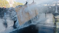 Estudiantes ayer en Par�s resistiendo el chorro del ca��n de agua de la polic�a.