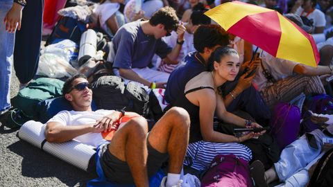 Los fieles esperan, tumbados sobre la calzada, aguardan la celebraci�n de la Vigilia.