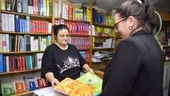 Clienta revisando los libros de texto en la librería Escolma de Pontevedra