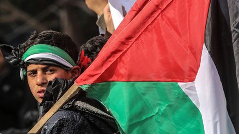Un nio sostiene una bandera palestina durante una protesta en Gaza contra el plan de Trump