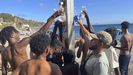 Migrantes cogen agua de las duchas para lavarse en la playa del trampol�n, en Ceuta