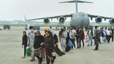 Evacuados de Afganistn caminan por la pista despus de desembarcar de un avin de la Fuerza Area India 