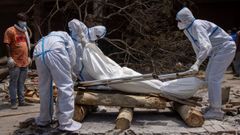 Un grupo de personas, preparando el cuerpo de una de las v�ctimas mortales del covid-19 para proceder a su cremaci�n