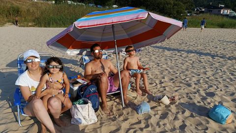 Ba�istas siguiendo el eclipse desde la playa de Area, en Viveiro