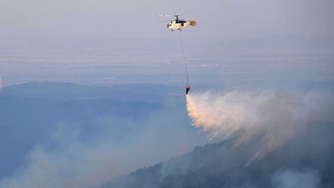 Un helic�ptero de bomberos trata de controlar los fuegos en el �rea de Leptokarya, en Evros, al norte de Grecia