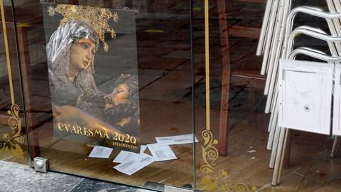 Vista de un cartel que anuncia la Semana Santa en un local comercial en Oviedo durante una nueva jornada marcada por el coronavirus.